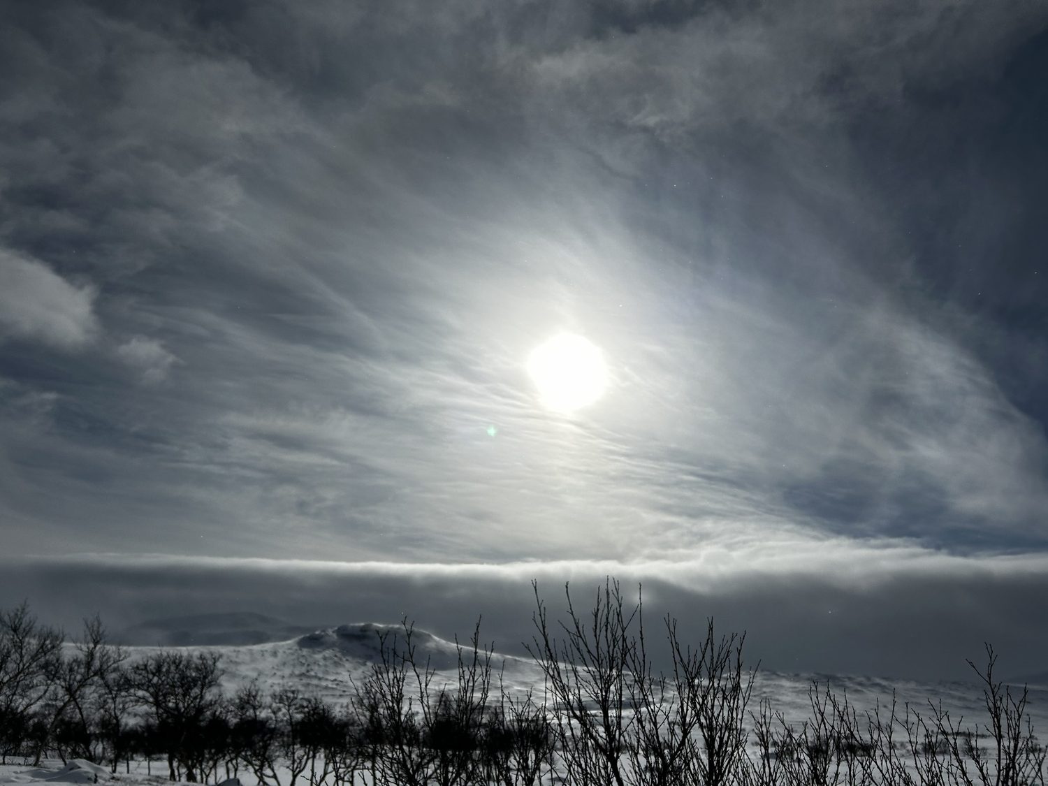 Vintersol över fjäll och dramatiska moln